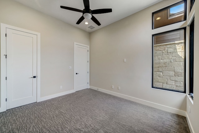 carpeted spare room featuring ceiling fan