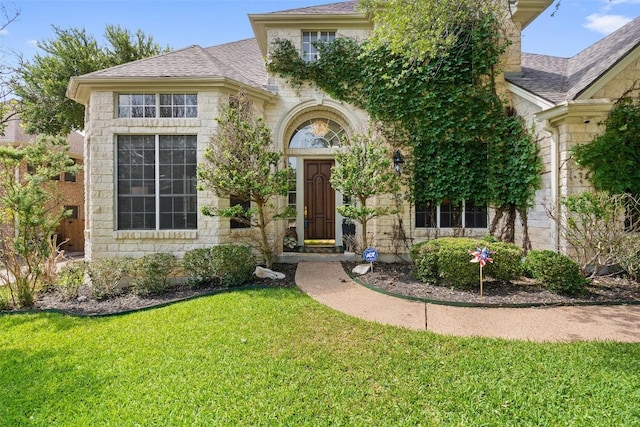 view of front of house featuring a front lawn and roof with shingles