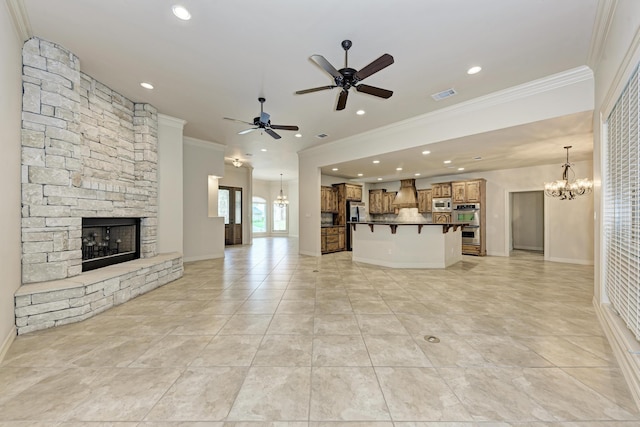 unfurnished living room with crown molding, light tile patterned floors, a fireplace, and ceiling fan with notable chandelier