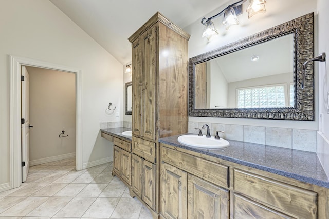 bathroom featuring tile patterned flooring, vanity, and vaulted ceiling