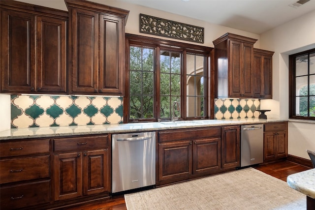 kitchen featuring stainless steel dishwasher, a healthy amount of sunlight, and backsplash