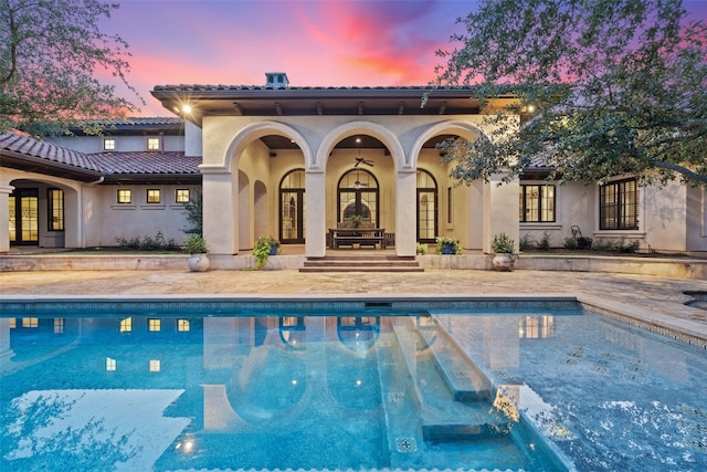 pool at dusk with french doors