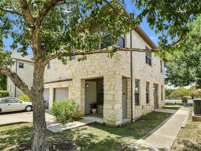 view of home's exterior with central AC unit and a garage