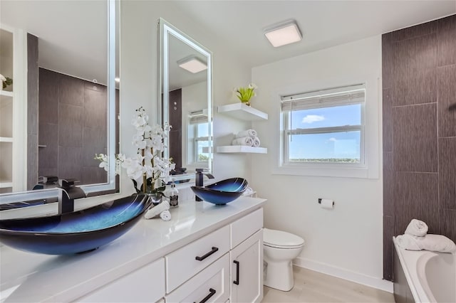 bathroom with a bathtub, hardwood / wood-style floors, vanity, and toilet