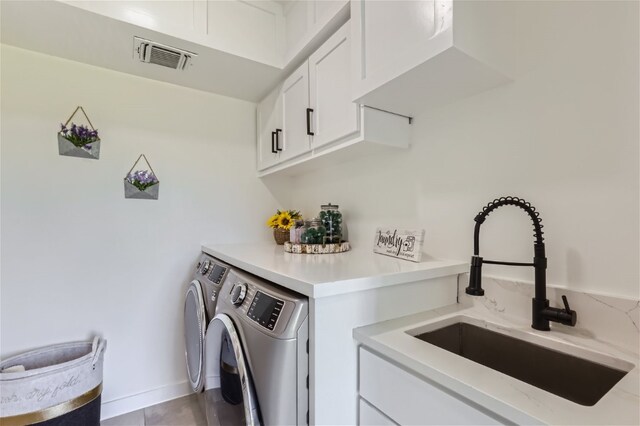 laundry area featuring cabinets, sink, and washing machine and clothes dryer