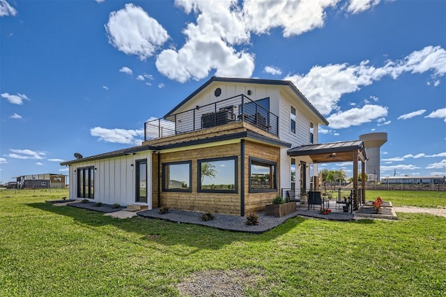 rear view of property featuring a lawn and a balcony