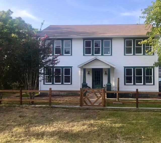 colonial home featuring a porch and a front lawn