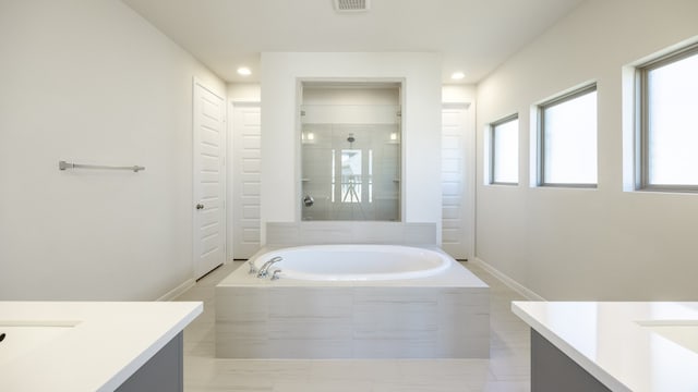 bathroom with tile patterned floors, vanity, and plus walk in shower