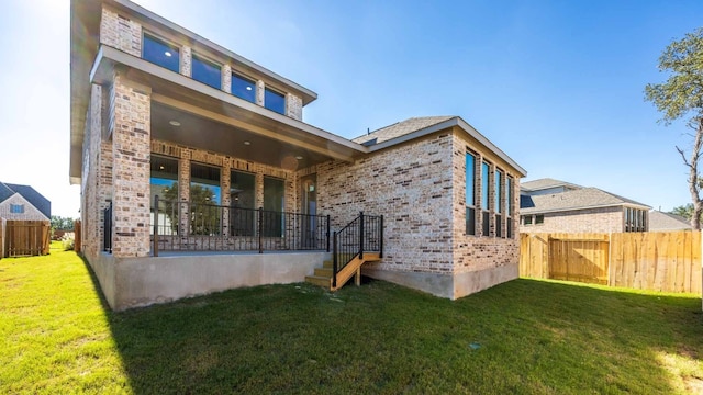 rear view of property featuring a yard