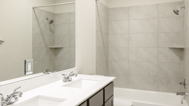 full bathroom featuring tiled shower / bath combo, vanity, and toilet