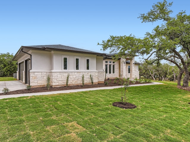 view of front of home featuring a garage, stone siding, a front yard, and stucco siding