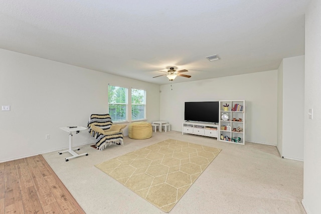 living room featuring light hardwood / wood-style flooring and ceiling fan