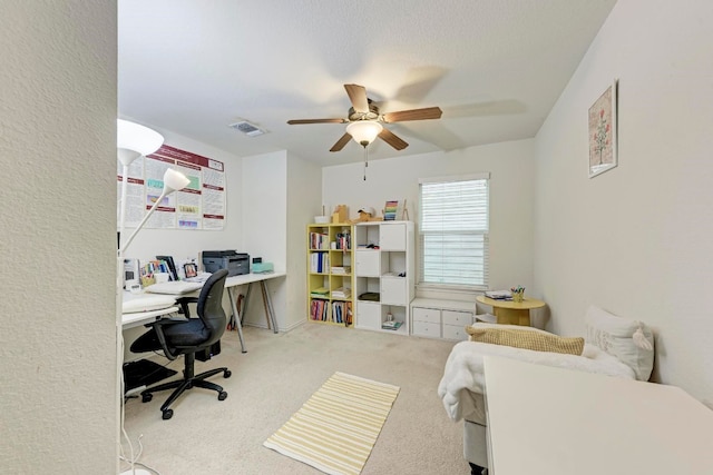 carpeted office space featuring ceiling fan