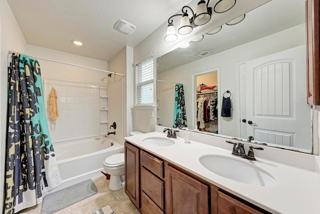 full bathroom featuring tile patterned flooring, double sink vanity, shower / bath combination with curtain, a textured ceiling, and toilet