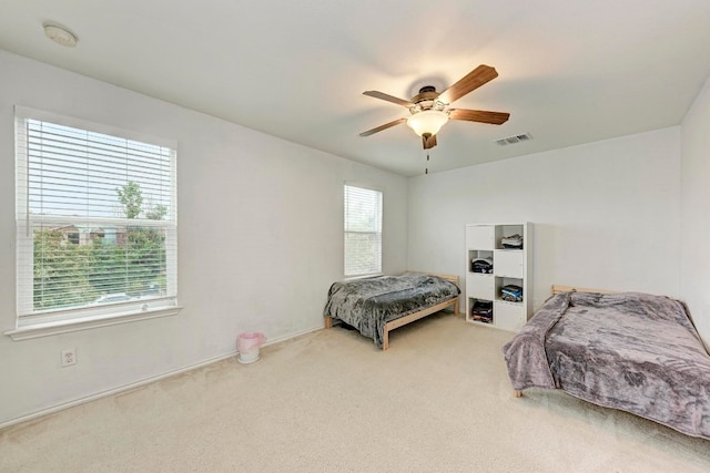 bedroom with multiple windows, carpet, and ceiling fan