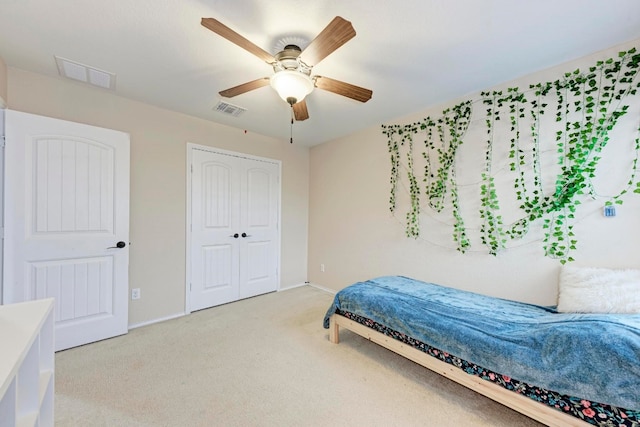 bedroom featuring light colored carpet, a closet, and ceiling fan