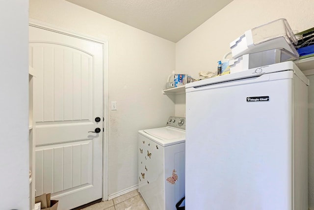 clothes washing area with washer and dryer and light tile patterned floors