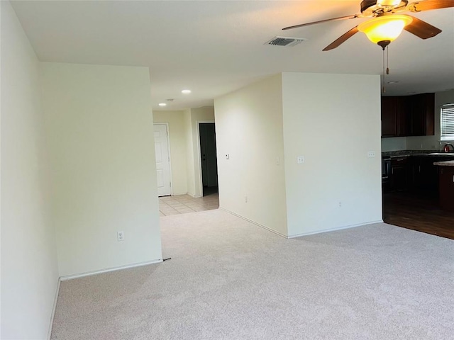 carpeted empty room featuring ceiling fan