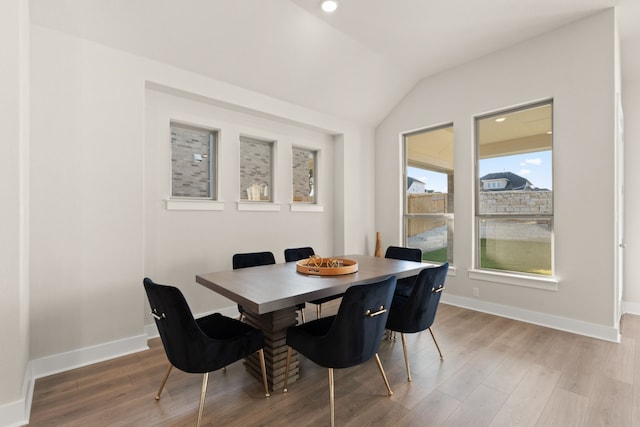 dining space with hardwood / wood-style flooring and lofted ceiling