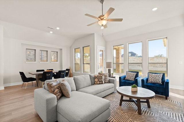 living room with ceiling fan, lofted ceiling, and light hardwood / wood-style flooring