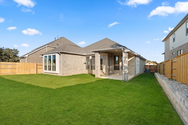 back of house featuring a patio area, central AC, and a yard