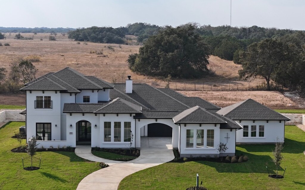 124 Rancho Deluxe, Liberty Hill, TX 78642 - view of front of property featuring driveway, french doors, a front lawn, a chimney, and stucco siding