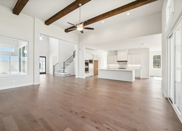 unfurnished living room featuring hardwood / wood-style floors and a high ceiling