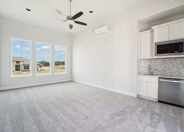 unfurnished living room with light carpet, sink, a wall mounted AC, and ceiling fan