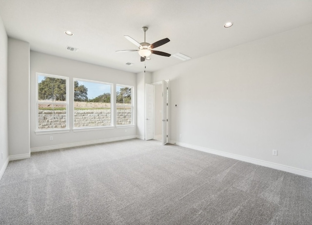 empty room with ceiling fan and light carpet