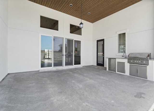 view of patio with sink, exterior kitchen, and a grill