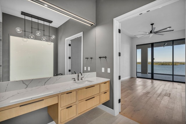 bathroom featuring hardwood / wood-style floors, a water view, ceiling fan, and vanity