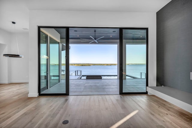 interior space featuring a wealth of natural light, wood-type flooring, and a water view