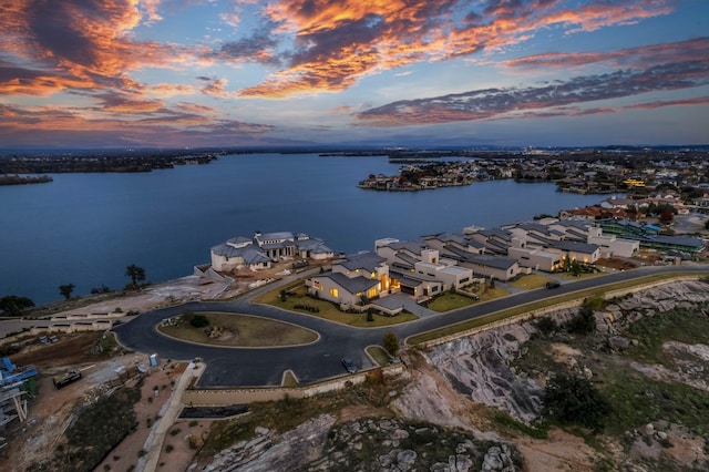 aerial view at dusk featuring a water view