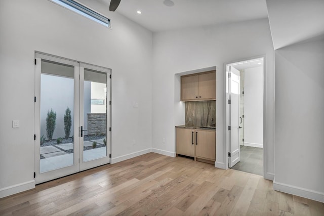 empty room featuring a high ceiling and light hardwood / wood-style floors