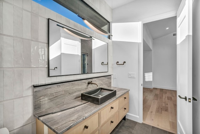 bathroom with hardwood / wood-style floors, vanity, and tasteful backsplash