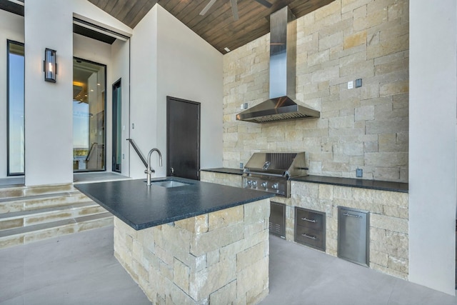 kitchen featuring a center island with sink, stainless steel fridge, wall chimney range hood, wood ceiling, and sink