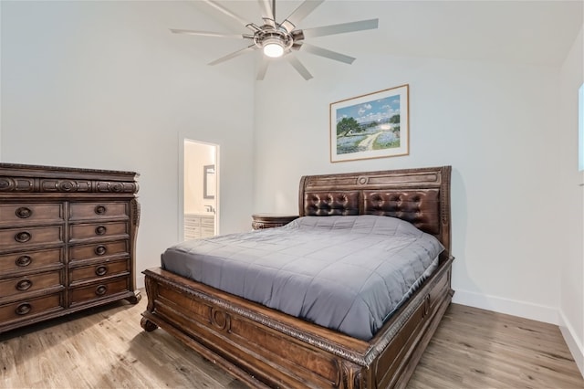 bedroom featuring light wood-type flooring, connected bathroom, vaulted ceiling, and ceiling fan