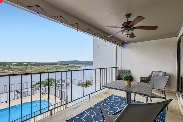 balcony with ceiling fan and a water view