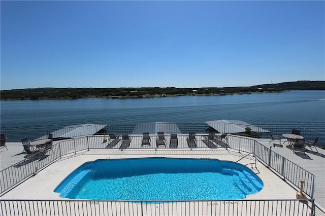 view of swimming pool featuring a patio and a water view