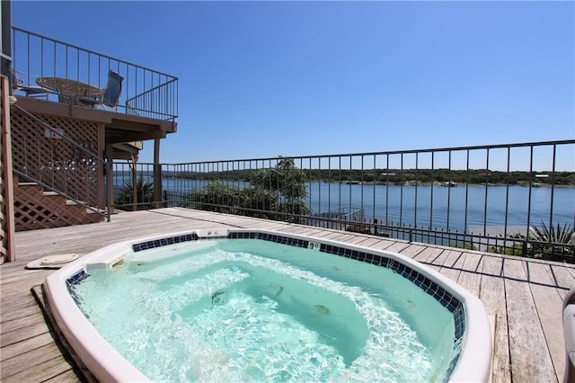 view of pool with a deck with water view