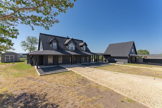 view of front of house featuring a front yard and a storage shed