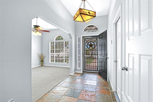 foyer featuring a towering ceiling, tile flooring, and ceiling fan