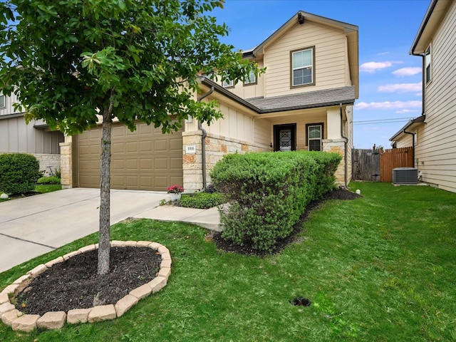 view of front of home with a garage, central AC, and a front lawn