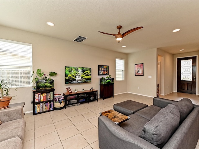 tiled living room with a textured ceiling and ceiling fan