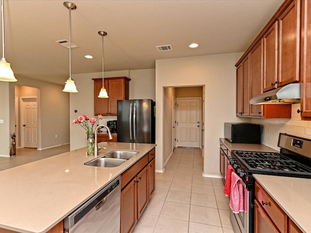 kitchen featuring appliances with stainless steel finishes, sink, an island with sink, and pendant lighting