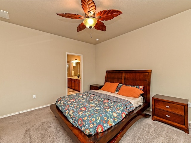 carpeted bedroom with ensuite bath and ceiling fan