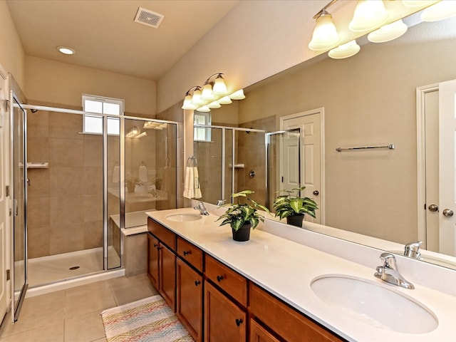 bathroom featuring dual bowl vanity, tile flooring, and a shower with door