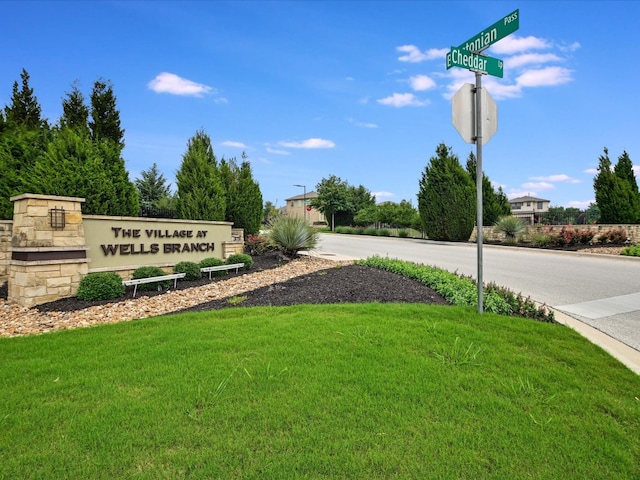 community / neighborhood sign featuring a yard