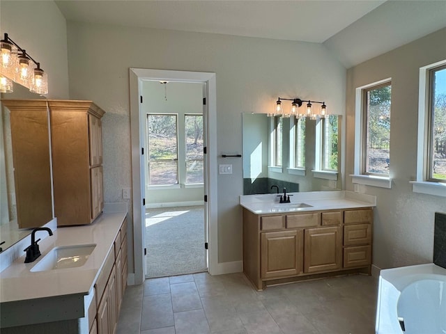 bathroom featuring tile patterned floors, vanity, and vaulted ceiling