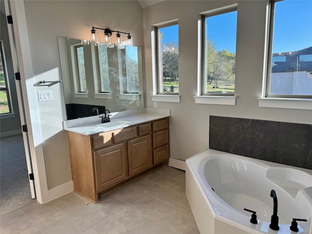 bathroom featuring tiled bath, tile patterned flooring, and vanity